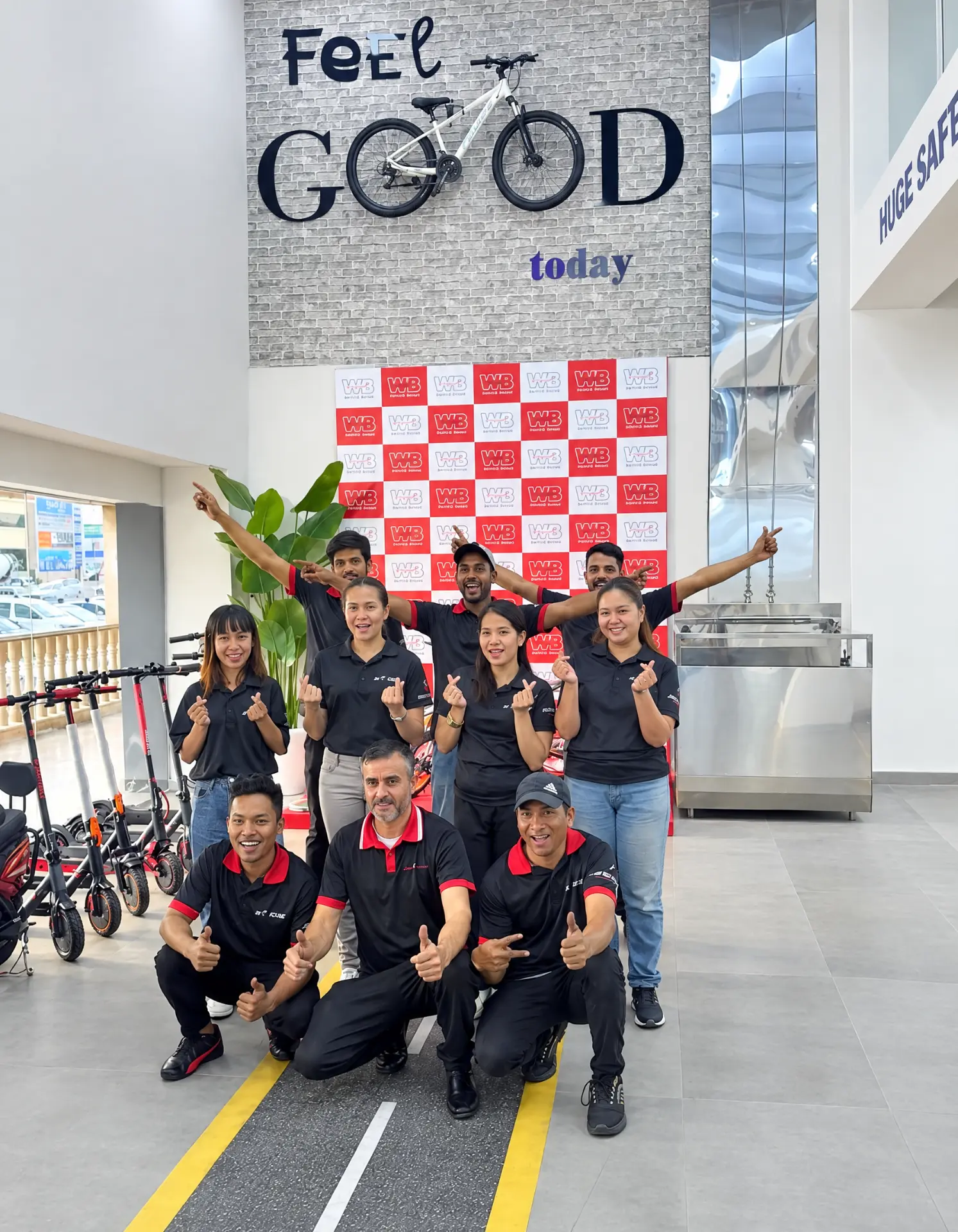 WB Bikes team under the Feel GOOD today wall inside the Al Quoz Mall store